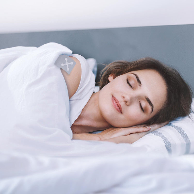 Glückliche Frau schläft entspannt mit der smart® Soft Blanket, der weichen nachhaltigen Ganzjahres-Decke mit PrimaLoft Bio Füllung aus Recyclingfasern